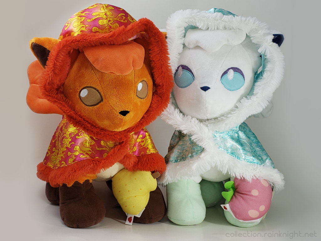 Both the Kanto and Alolan Vuplix Build-A-Bear plushes side by side wearing their respective cape outfits and holding berry wristies.